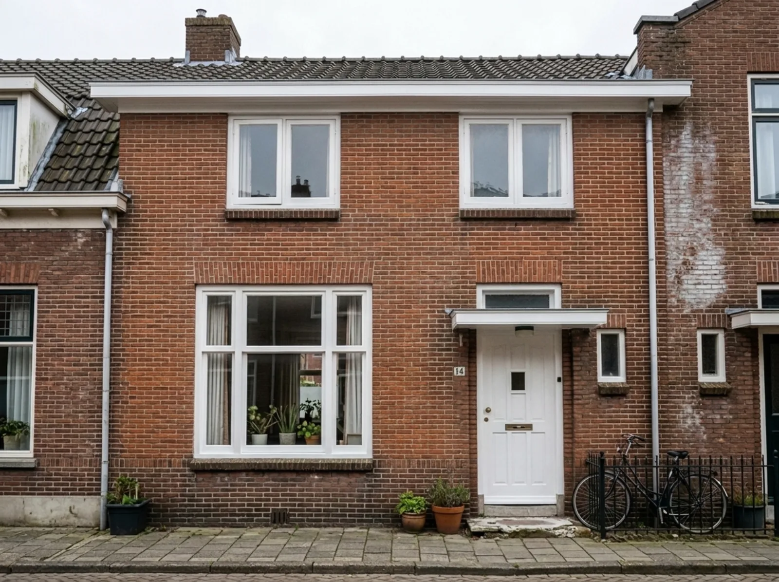 Na: dezelfde gevel schoon, met nieuw voegwerk en strak geschilderde kozijnen